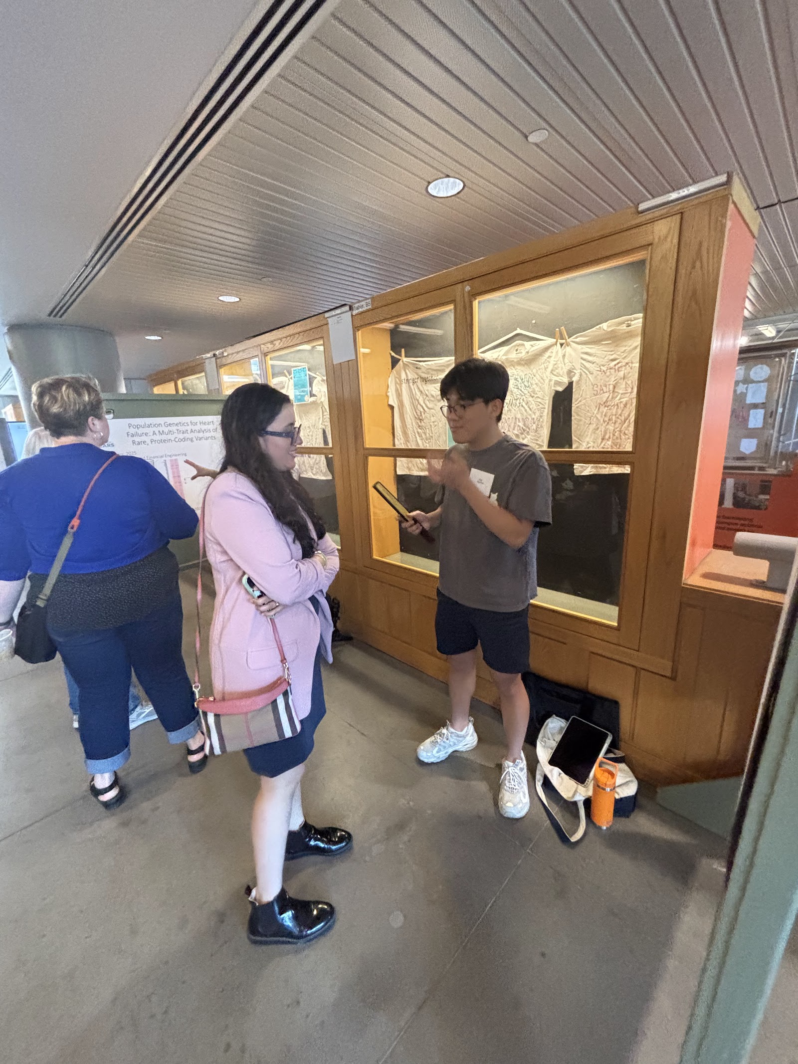 Attendees talking in front of a wood-framed natural-history exhibit case.