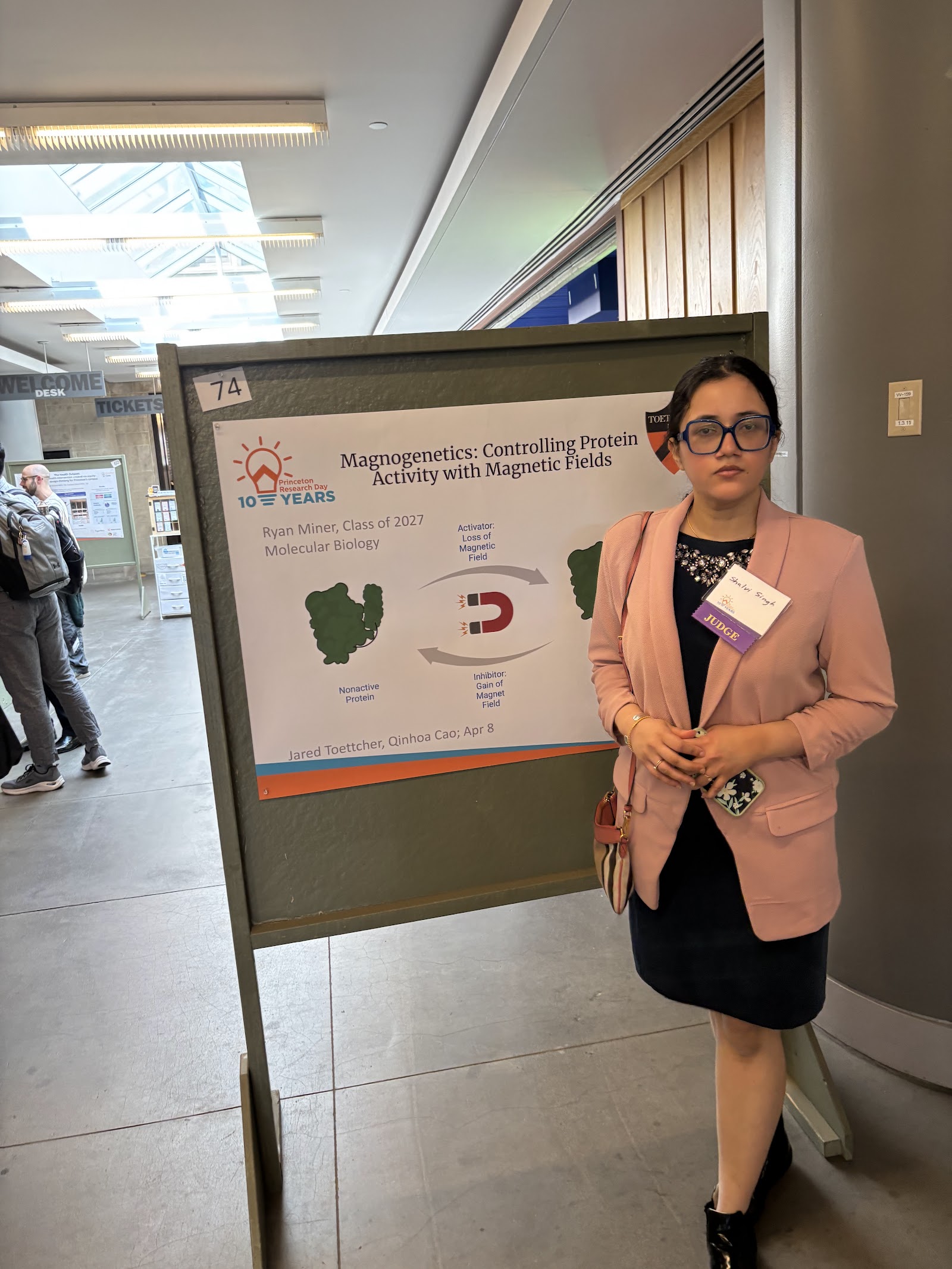 Shalvi next to poster 74, titled “Magnetogenetics: Controlling Protein Activity with Magnetic Fields.”