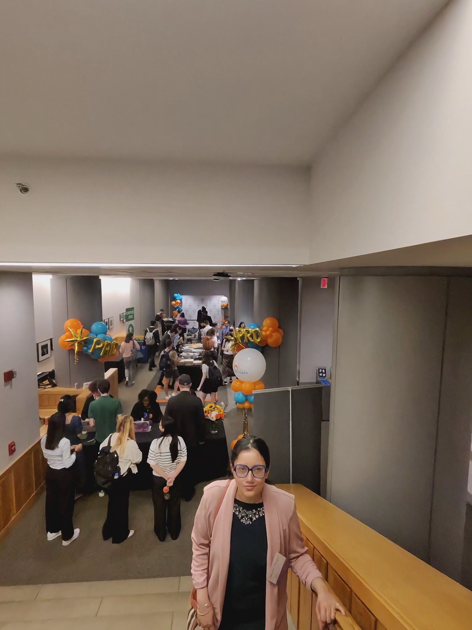 An overhead view of the crowded event floor with balloons and exhibit tables.